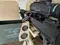 Belt-fed 7.62mm machine gun with magnified optic on a tripod